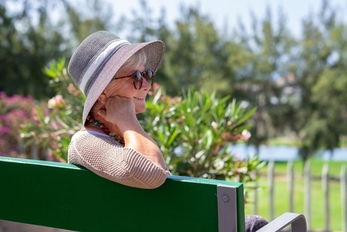 Portrait,Of,Beautiful,Senior,Woman,Wearing,Cap,And,Sunglasses,Sitting